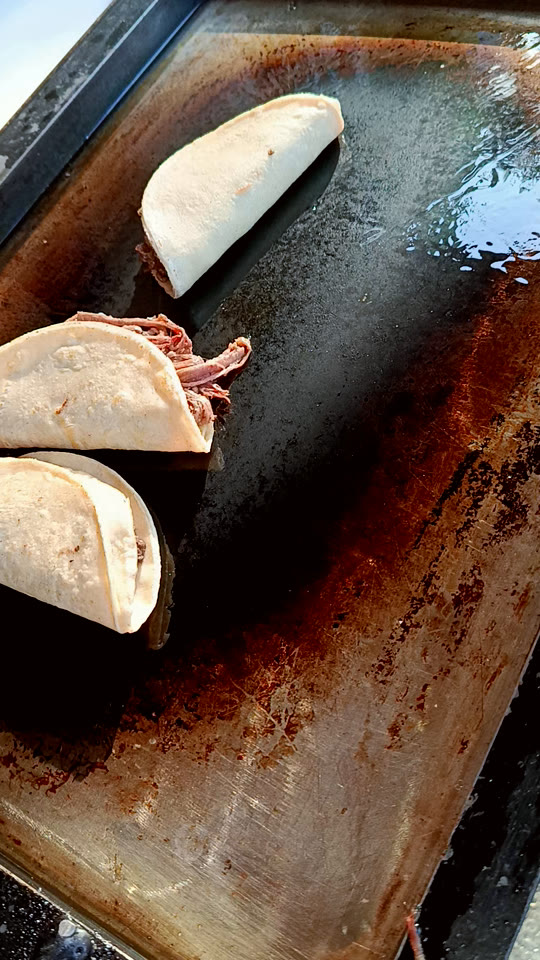 Armado de un taco de barbacoa sobre tortilla de maíz